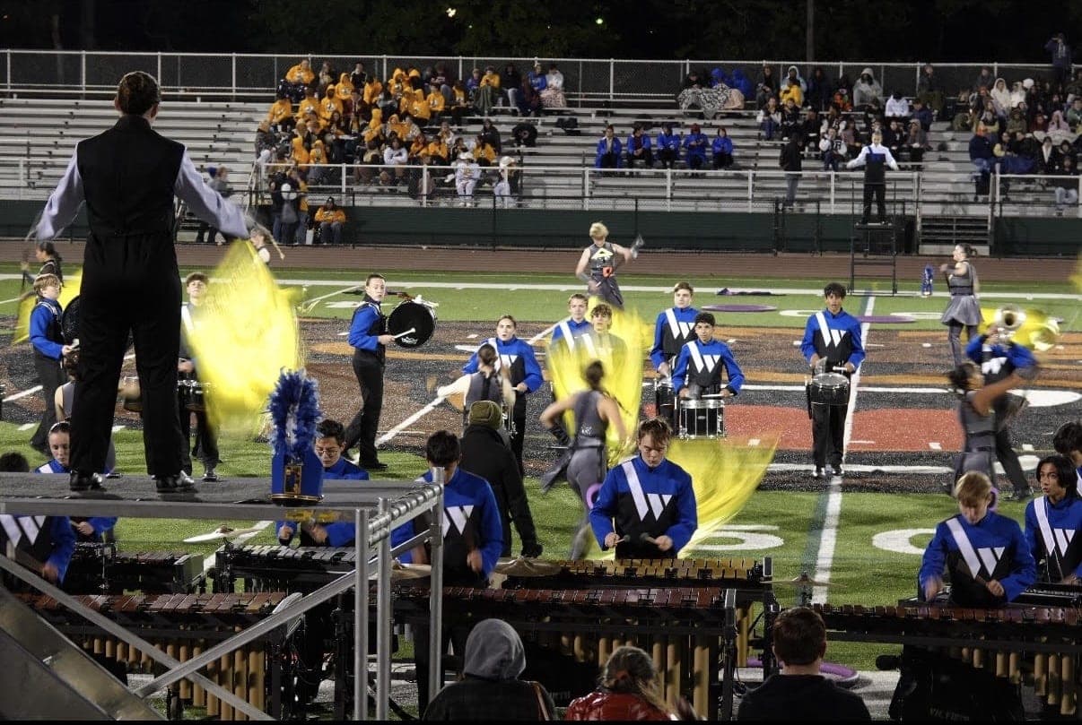 A drum major conducts the Marching Blue Devils as the front ensemble and drumline perform.