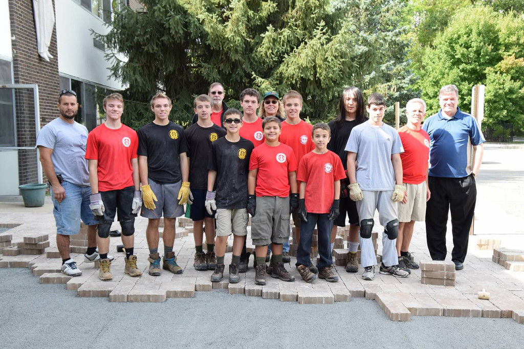 (above) John Trovato's Eagle project was building a patio area with shrubs and picnic tables outside Our Lady of the Mount Catholic Church in Warren. On this day troop 228 scouts and adults (w/Father Sean on the far right) were laying down the pavers.