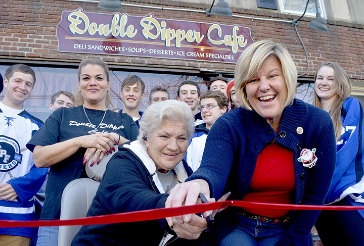 (above) Mayor Colleen Mahr, right, and Double Dipper Cafe co-owners Linda Naso, seated, and her daughter, Jerry Quail, behind Naso, cut the ribbon to officially open the Double Dipper ice cream store under new ownership in Fanwood Sunday, Dec. 6. Several customers and the hockey team from Scotch Plains Fanwood High School cheered on the proceedings at the shop on Martine Avenue in downtown Fanwood.