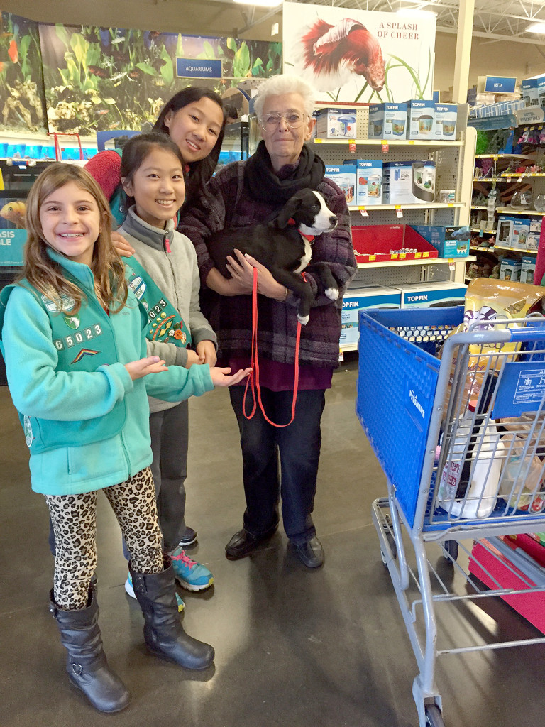 (above l-r) are Keria L., Kaitlyn Z. and Andrea Yan with Laurie from Rawhide Rescue holding a newly adopted puppy.