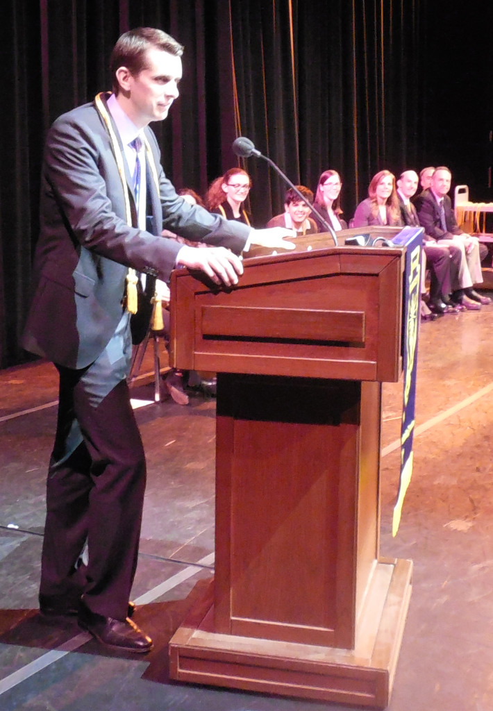 (above) The new members of the 2015 Watchung Hills chapter of the National Honor Society Teacher of the Year, Greg Biniukow, thanked the students for selecting him, and recalled happy memories as their social studies teacher. Among the other people on stage who can be recognized in the background are, from left: Students Alyssa Rosenblum of Millington and Ajey Gangwani of Breen Brook Township; faculty advisor and Chemistry Teacher Michelle Madigan; Superintendent Elizabeth Jewett; Principal George Alexis, and Vice Principals Steven Searfoss and, partially blocked, Terry MacConnell.
