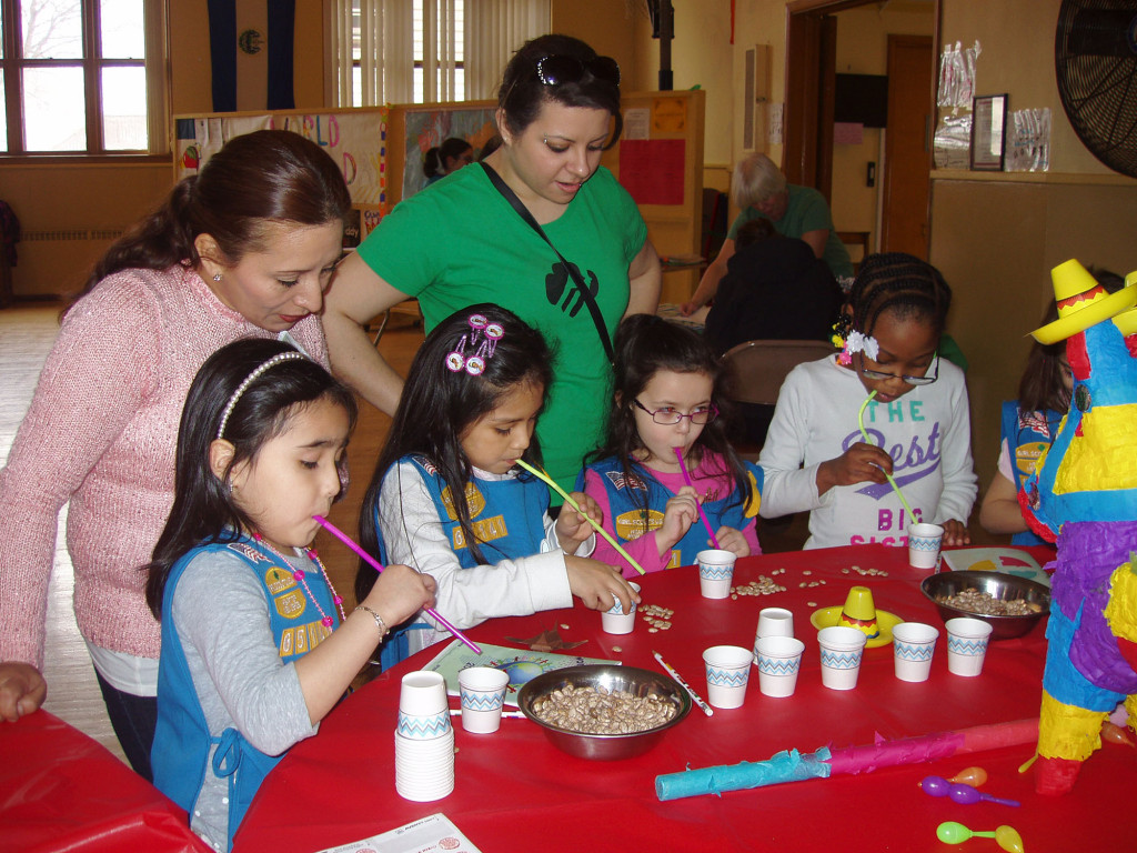 (above) These Daisy Girl Scouts are enjoying sucking up as many pinto beans as they can with a straw and putting them in to a cup in one minute while the Mexican Hat Dance music plays in the background.