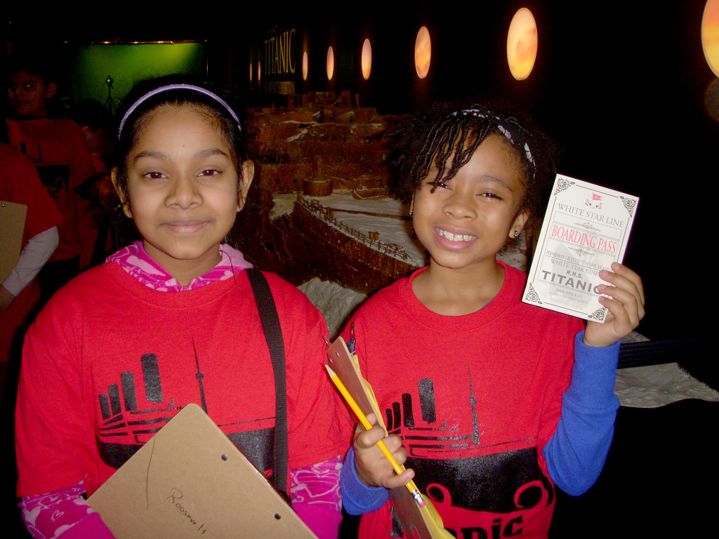(above, l-r) Anisha Subramanie and Mariel Woodson showing her boarding pass. The girls enjoyed assuming the roles of passengers.