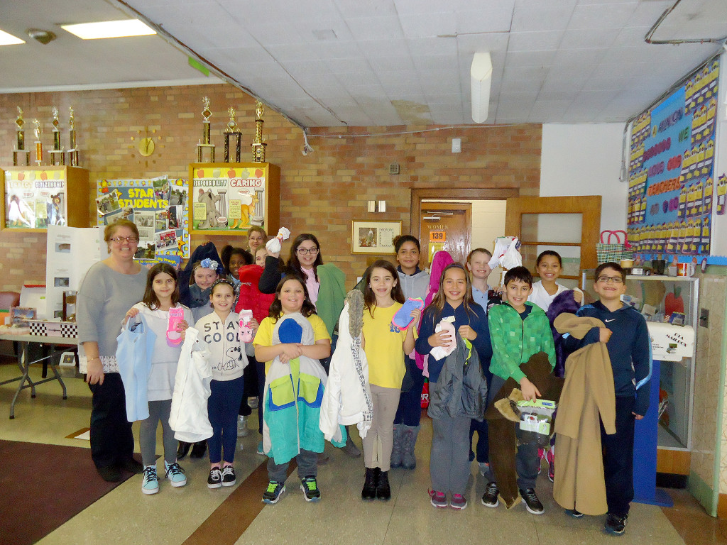 The students hold up their collected coats, socks and such. Photo by Linden School No. 10