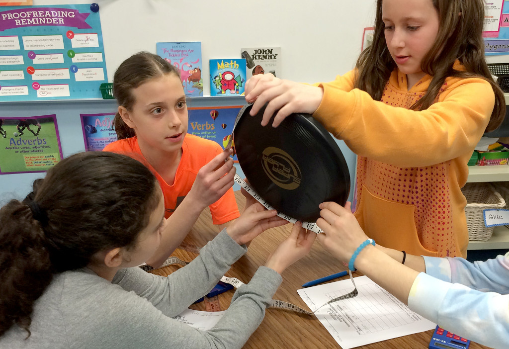 (above l-r) Central School 5th graders Samantha Traister, Lauren Rich, and Claire Gillenwater measure the circumference and diameter of a Frisbee to celebrate Pi Day on 3/14.