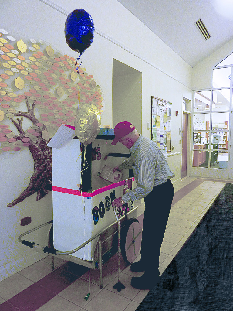 (above) Patron donates books at the donation cart at the library.