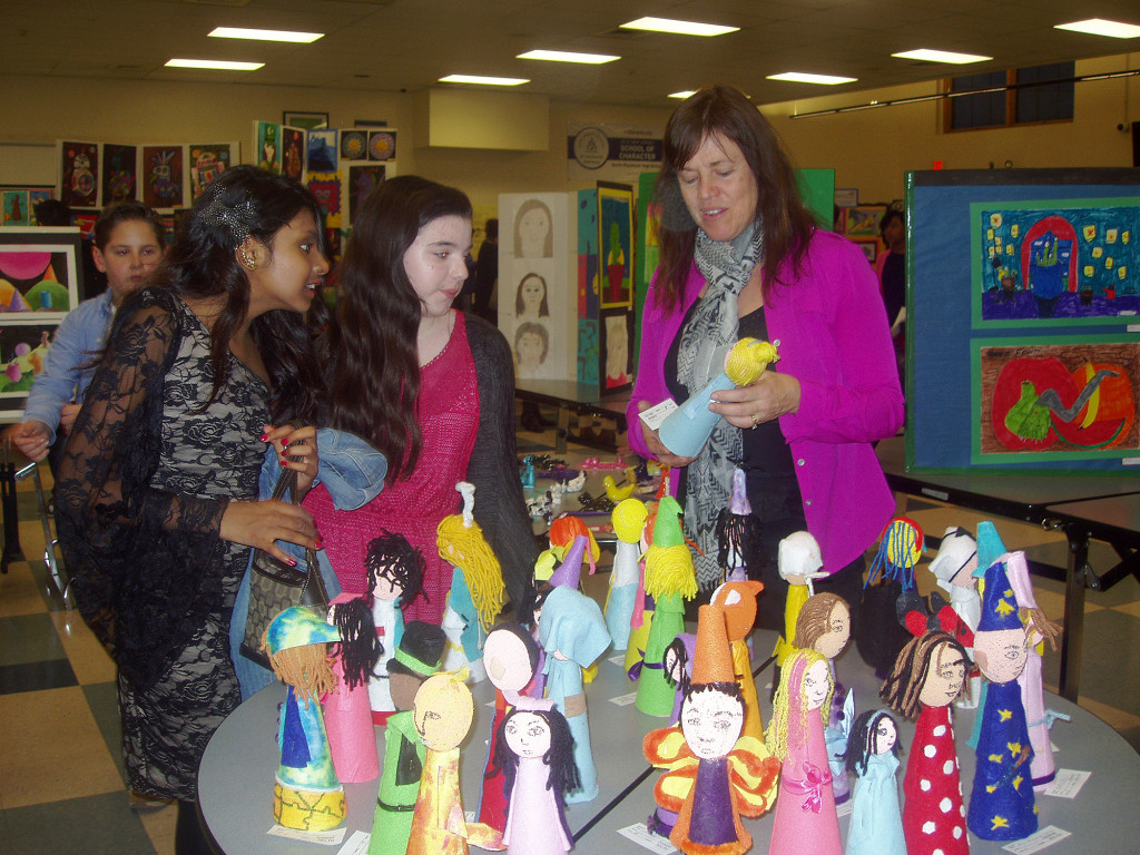 (above) North Plainfield High School Ceramic and Somerset Intermediate School Art teacher Kathie Fry pictured with from left to right sixth graders Farah Baijnath and Nicole Lindemeyer – as they view the 3-D art forms called “Wizards.”
