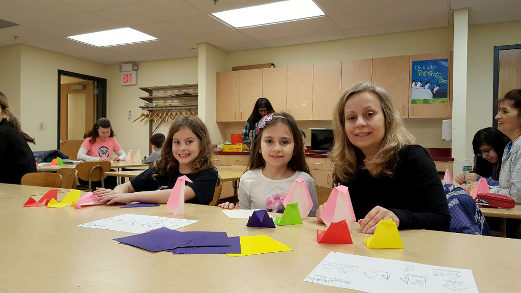 (above l - r) Isabella DeLuca, Angela Navroski and Anabela Navroski enjoy a Story-gami program during spring break at the Library.