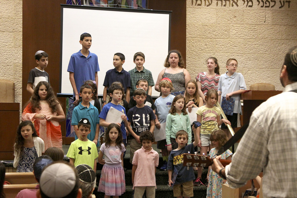 (above) Second- and seventh-grade students sing at the conclusion of their joint Moving Up ceremony under the direction of Cantor Matt Axelrod.