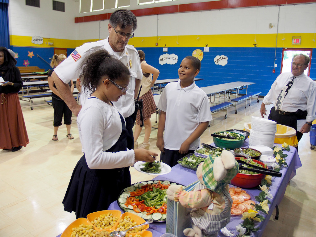 (above) Students Jocelyn Nova, Linden Fire Chief Joseph Dooley, and Kyle Gutierrez make a salad together. Jocelyn said "We invited the firefighters to eat a healthy salad with us because they in the beginning of the year they were strangers and they are now our friends. "Kyle told the Chief that firefighters are important because they help, even if they are at recess and they have a disagreement they will still save your life. That is being a good citizen and good character.