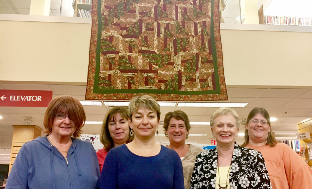 (above) Friends of the Library are standing in front of a handmade quilt that is being raffled off during the anniversary weekend. (L-r)Lois Bohm, Lisa Jennings, Kim Cokelet, Joan Sinclair, Kim Alongi and Karen DeMarco.