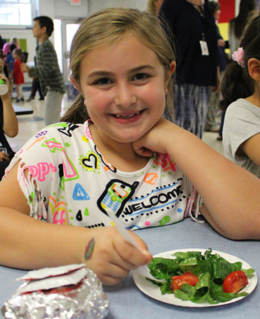 (above) Central 3rd grader Ashley Parker enjoys a true farm-to-table experience with fresh produce from the school garden.